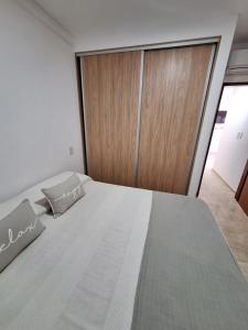 a bedroom with a large bed and a wooden door at Artigas 505 dpto 2 in Colón