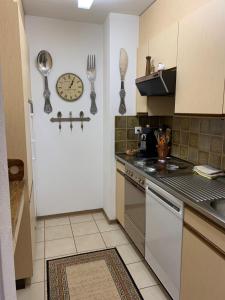 a kitchen with a clock on the wall and a counter at Small bijoux Disentiserhof in Disentis