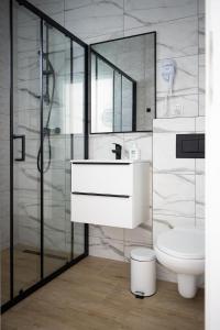 a bathroom with a white sink and a toilet at Morski Las in Ustronie Morskie +78 photos
