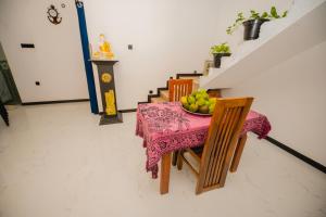 a dining room table with a bowl of fruit on it at Enu Homestay in Dickwella