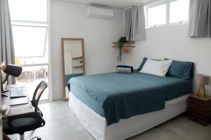 a bedroom with a bed and a desk and a chair at Kicoh - Kite Community House in Itarema