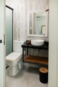 a bathroom with a toilet and a sink and a mirror at Kicoh - Kite Community House in Itarema +20 photos