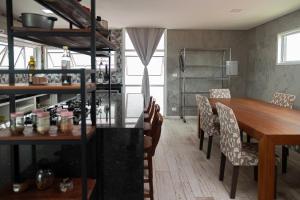 a dining room with a wooden table and chairs at Kicoh - Kite Community House in Itarema