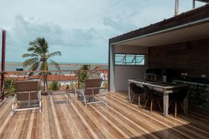 a deck with a table and chairs and a view of the ocean at Kicoh - Kite Community House in Itarema