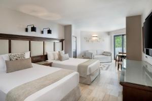 a hotel room with two beds and a flat screen tv at Grand Palladium Vallarta Resort & Spa - All Inclusive in Punta Mita +108 photos