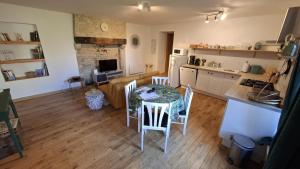 a kitchen with a table and chairs in a room at Émeraude in Voulême +4 photos