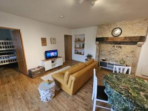 a living room with a couch and a clock on the wall at Émeraude in Voulême