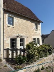a brick house with a fence in front of it at Le logis in Mairé