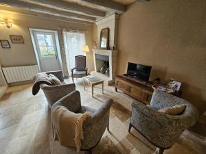 a living room with chairs and a flat screen tv at Le logis in Mairé