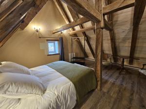 a bedroom with a white bed in a attic at Le logis in Mairé