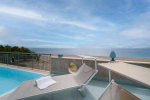 a balcony with a bench and a swimming pool at Aurora View Resort - Boutique Suites in Mascali