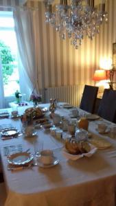 a long table with plates and dishes on it at La pocterie in Vouneuil-sur-Vienne