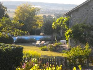 a garden with a swimming pool and a house at La pocterie in Vouneuil-sur-Vienne +2 photos