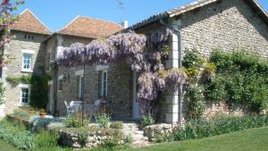 a house with a wreath of purple flowers on it at La pocterie in Vouneuil-sur-Vienne