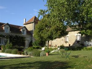 a house with a table and chairs in the yard at La pocterie in Vouneuil-sur-Vienne