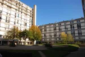 a large white building with trees in front of it at Paris visite in Ivry-sur-Seine