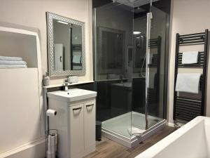 a bathroom with a shower and a sink and a mirror at Blue Sky Cottage in Matlock +23 photos