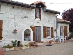 a white brick house with a patio in front of it at La cornouillère in Champau +8 photos
