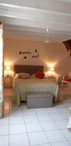 a bedroom with a bed with a sign on the wall at La cornouillère in Champau