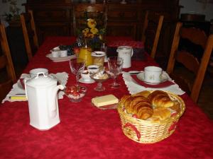 a table with a red table cloth with a basket of bread at La cornouillère in Champau