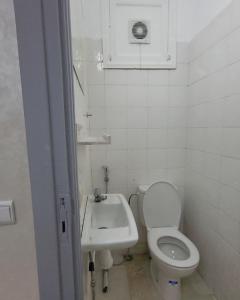 a white bathroom with a toilet and a sink at your cute house in Salé +17 photos