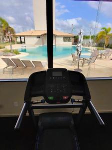 a view of a swimming pool from a gym with a treadmill at Kite House Lençóis II in Santo Amaro