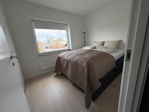 a small bedroom with a bed and a window at Bexam Apartment in Växjö