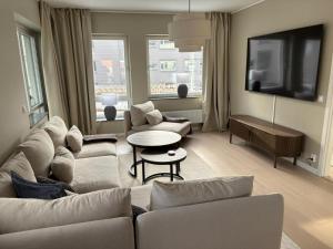 a living room with a couch and a tv at Bexam Apartment in Växjö