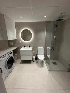 a bathroom with a toilet and a sink and a shower at Bexam Apartment in Växjö +10 photos