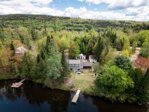 an aerial view of a house in the middle of a river at Chalet rustique, Lac paisible, Canot, Famille in La Conception