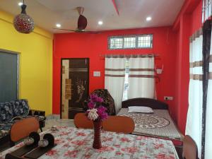 a room with a bed and a red wall at DENEVA Inn in Nowgong