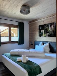 a bedroom with a large white bed and a window at Chalet Hirschegg - modernes Dorfchalet mit Panorama in Leutasch