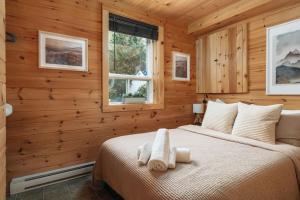 a bedroom with a bed in a log cabin at Chalet rustique, Lac paisible, Canot, Famille in La Conception