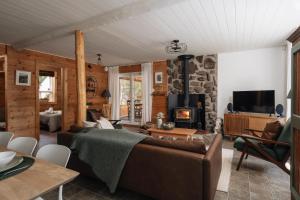 a living room with a couch and a fireplace at Chalet rustique, Lac paisible, Canot, Famille in La Conception