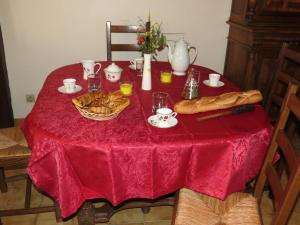 a table with a red table cloth and bread on it at La boulitte in Asnois