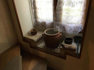 a window with three pots sitting on a window sill at La boulitte in Asnois