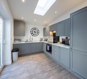 a kitchen with gray cabinets and a skylight at Runswick Road in Bristol +27 photos