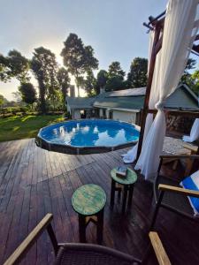 a large swimming pool on a wooden deck with chairs at Kitanda Msituni in Meru