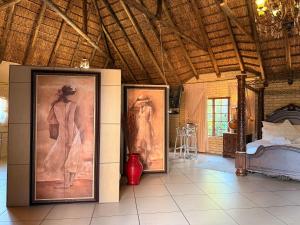 a room with two paintings of a woman and a bed at Accommodation At Thabong in Brakpan