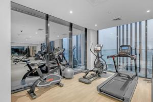 a gym with several cardio machines in a building at Waves - Modern & Vibrant Studio With Skyline View in Sabkhah