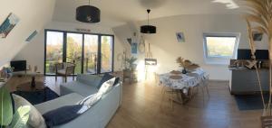 a living room with a couch and a table at Rose et violette in Brélès +9 photos