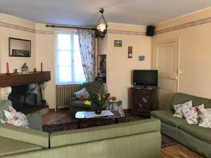 a living room with two couches and a fireplace at La forge de louis in Saint-Macoux