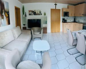 a living room with a couch and a kitchen at Ferienwohnung Gründlinger in Weilersbach