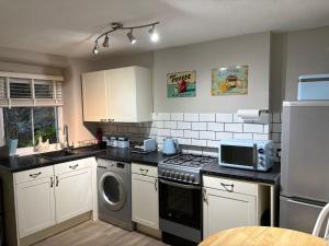 a kitchen with a stove and a dishwasher at Blue Sky Cottage in Matlock