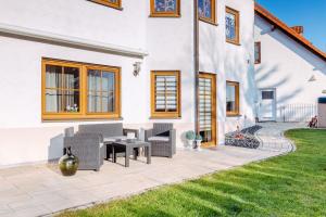 a patio with chairs and a table next to a house at Ferienwohnung Gründlinger in Weilersbach