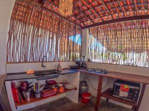 a kitchen with a counter and a sink and some windows at Casa do Francês in Japaratinga +26 photos
