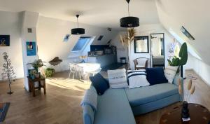 a living room with a blue couch and a table at Rose et violette in Brélès