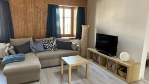 a living room with a couch and a tv at Tgesa communala Mon in Mons +4 photos
