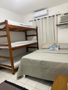 a bedroom with two bunk beds and a microwave at Refugio arraial in Arraial do Cabo +4 photos