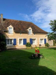 a house with blue doors and a red chair in a yard at Le ry de pouzioux in Chauvigny